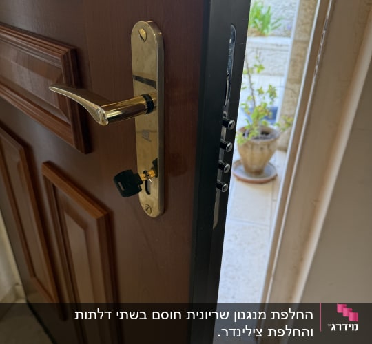 מפתח מוכנס לצילינדר ומנגנון מנעול מותקן בדלת כניסה מעוצבת